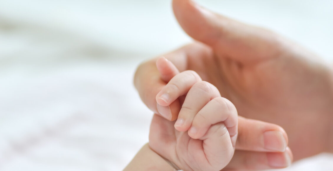 Mão de mulher e de bebê