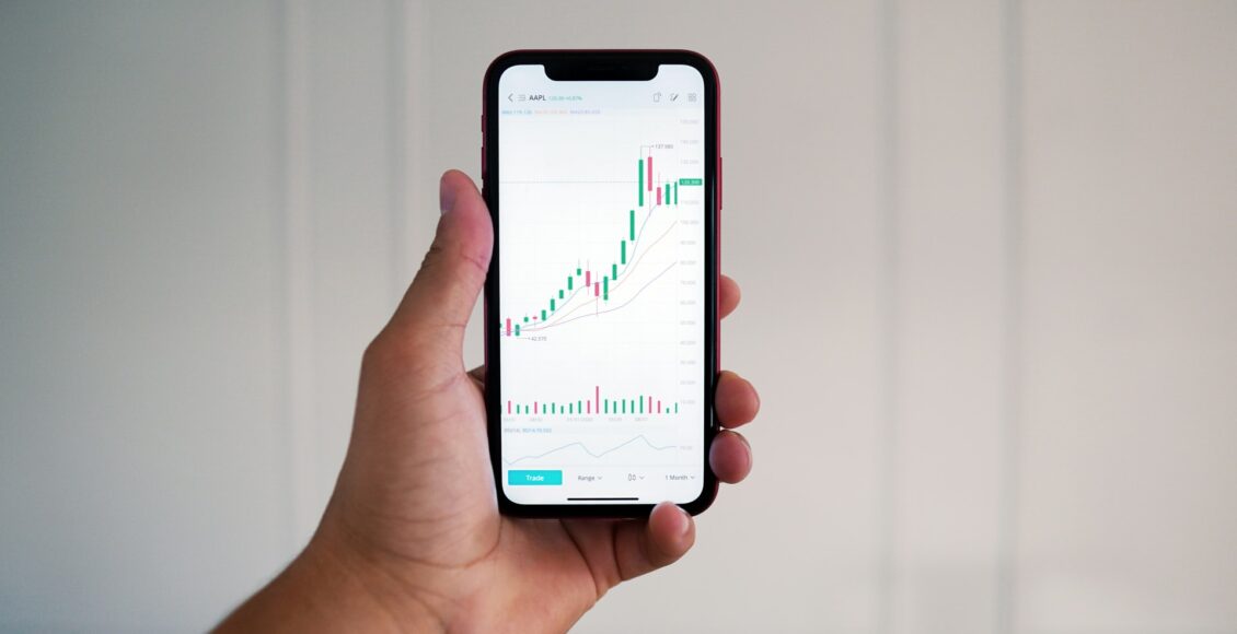 Celular na mão de uma pessoa mostra um gráfico