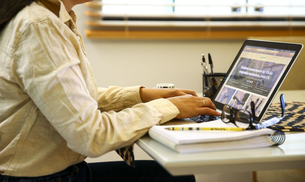 Na foto, uma mulher mexe no computador em casa; veja como fazer home office para o Google nesta matéria - Foto: Marcelo Camargo/Agência Brasil