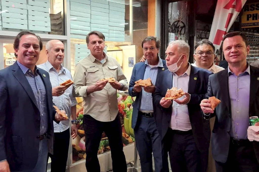 Bolsonaro junto a outros ministros, comendo pizza do lado de fora de restaurante em nova york, no dia anterior ao discurso na onu
