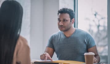 Foto mostra trabalhadora e empregador conversando sobre pedido de demissão
