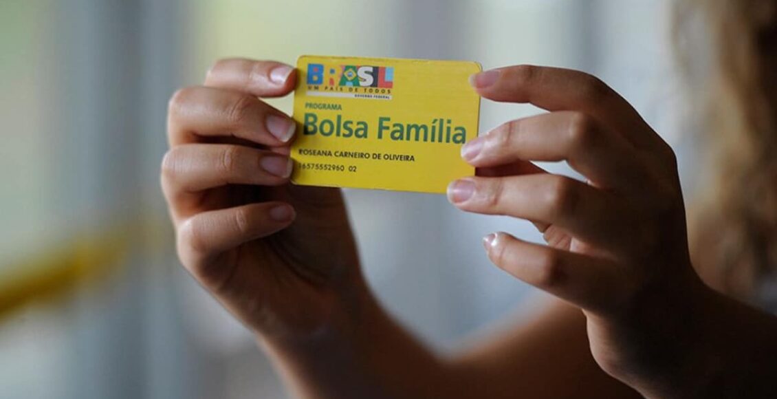 mãos segurando um cartão do Bolsa Família