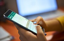 celular com o WhatsApp em mãos bloqueando conversa