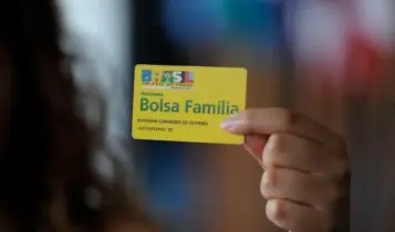 mão segura cartão de Pagamento do Bolsa Família